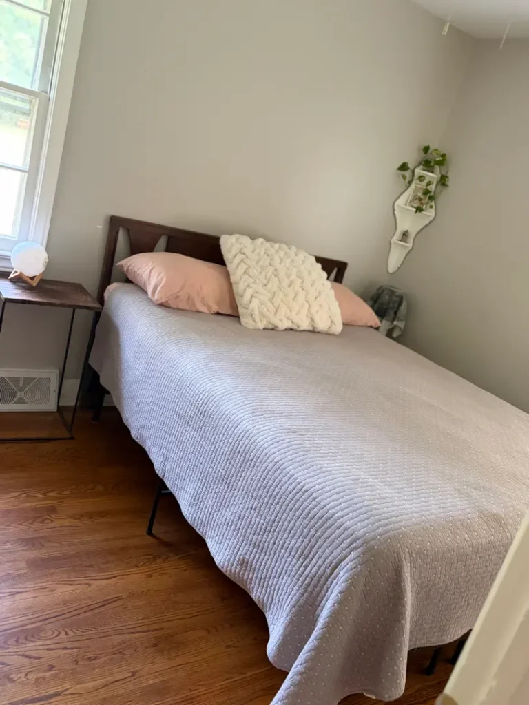 Neatly made bed and clean hardwood floors after general house cleaning in Greenville, SC