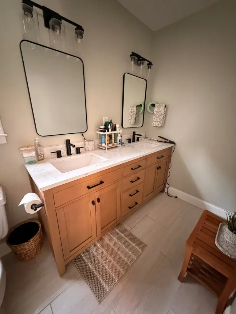 Wooden bathroom vanity with a white countertop, sink, and mirrors in a Greer, SC home maintained with recurring cleaning.