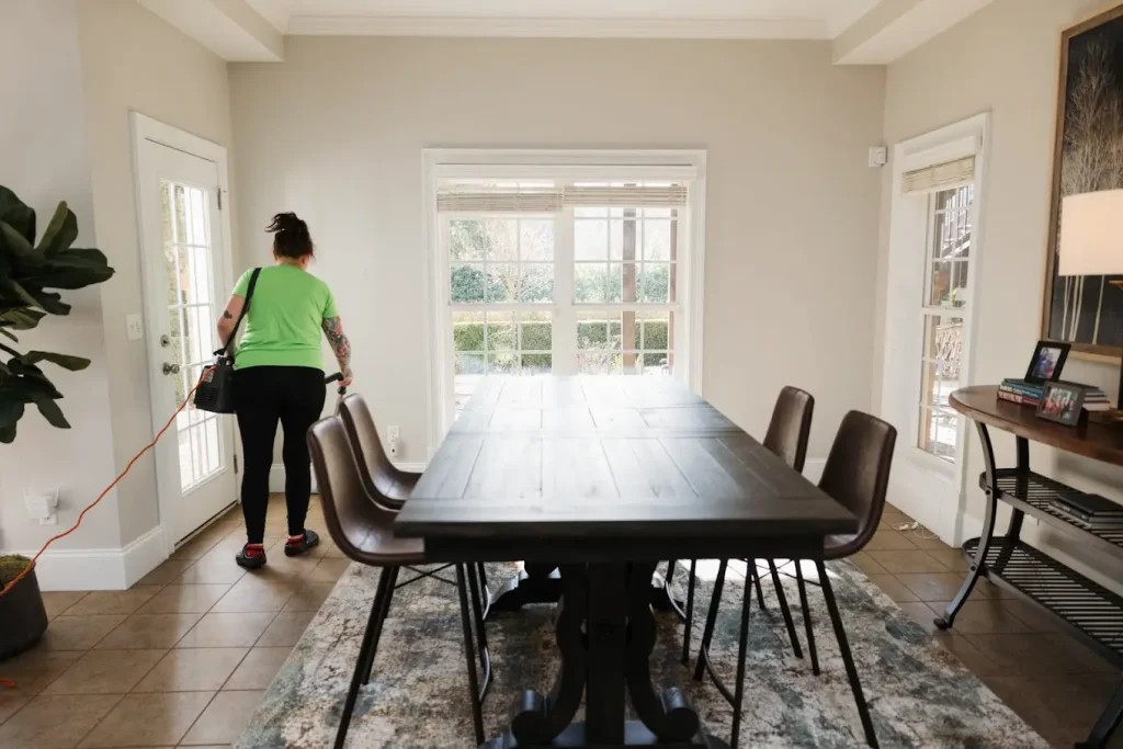 Busy Beez Cleaning team member vacuuming the dining room floor during a house cleaning service in Greenville, SC.