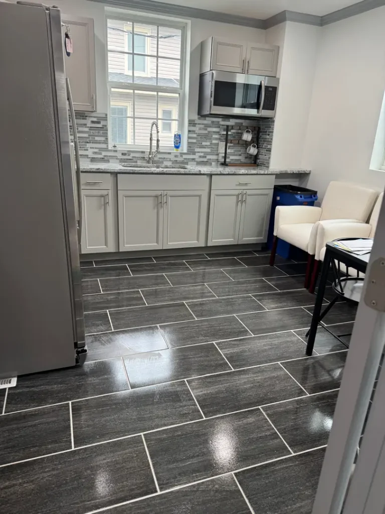 Clean office kitchenette with cabinets, countertops, and tiled floors in Greenville, SC